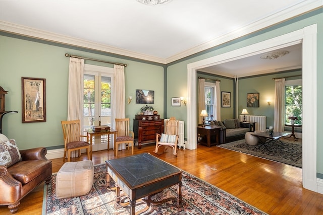 living room featuring crown molding, radiator, and hardwood / wood-style floors