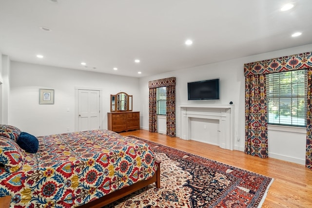 bedroom with light hardwood / wood-style flooring and multiple windows