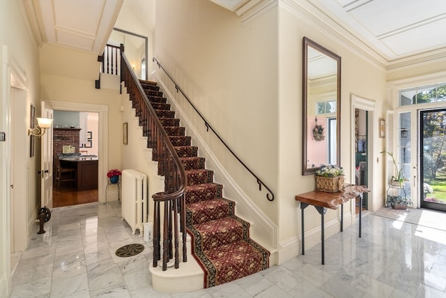 foyer featuring crown molding and radiator heating unit