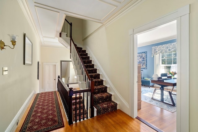 stairway with hardwood / wood-style flooring and crown molding