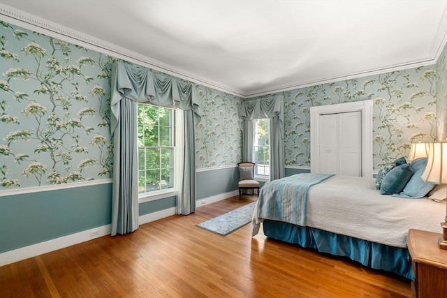 bedroom with crown molding, hardwood / wood-style flooring, and multiple windows