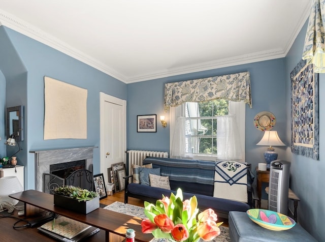 living room with ornamental molding, a high end fireplace, radiator heating unit, and wood-type flooring