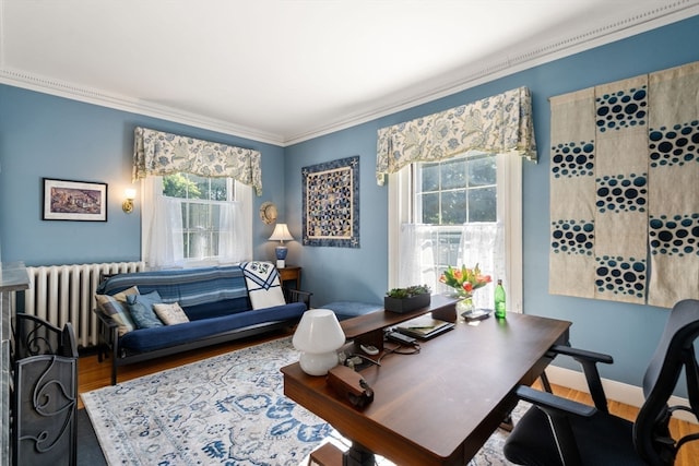 home office featuring wood-type flooring, radiator heating unit, ornamental molding, and a healthy amount of sunlight