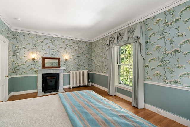 unfurnished room featuring ornamental molding, radiator, and wood-type flooring