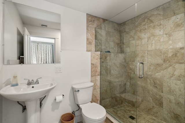 bathroom featuring toilet and an enclosed shower