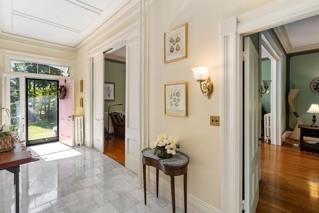 entryway with radiator, crown molding, and light hardwood / wood-style floors