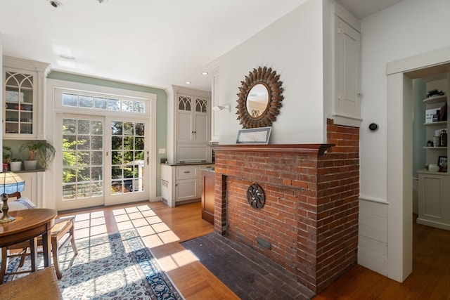 interior space with light wood-type flooring and a brick fireplace