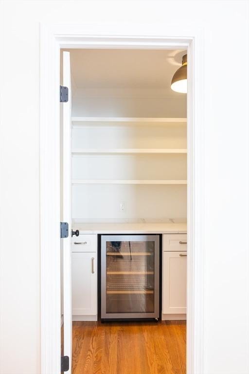 bar featuring beverage cooler and light wood finished floors