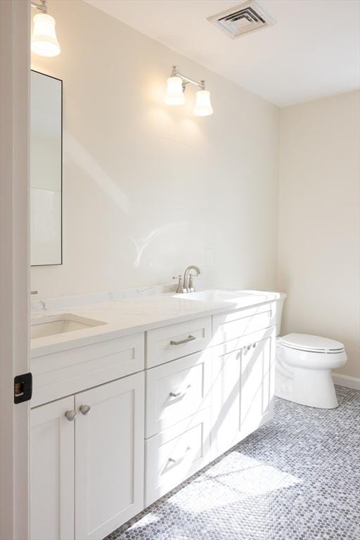 full bath featuring visible vents, a sink, toilet, and double vanity