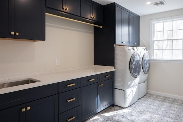 clothes washing area with visible vents, baseboards, cabinet space, and washer and dryer