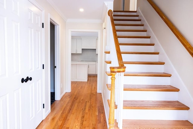 stairway featuring ornamental molding, wood finished floors, and recessed lighting