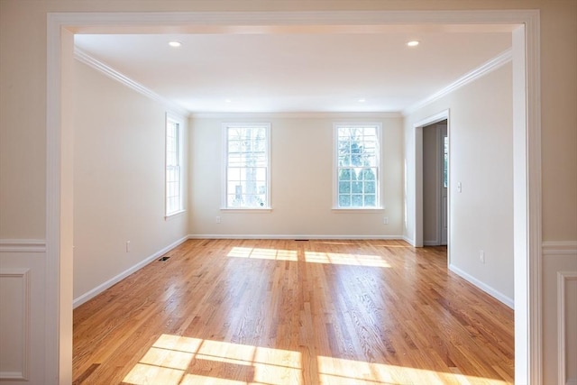 spare room with ornamental molding, recessed lighting, light wood-style floors, and baseboards