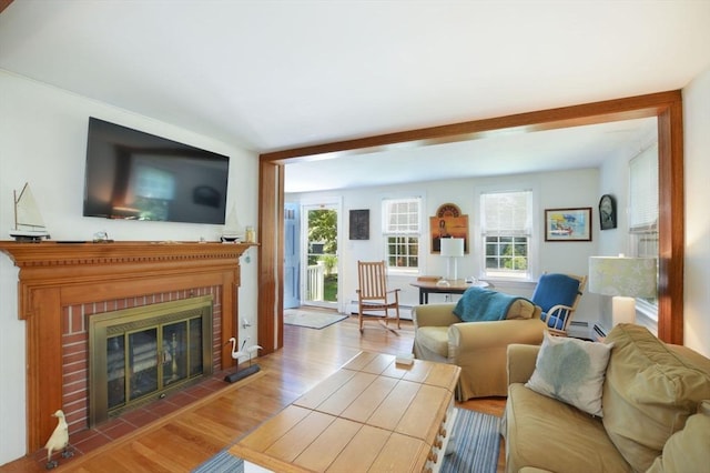 110 Teaticket Path, Falmouth, MA 02536 - living room with wood finished floors, healthy amount of natural light, a fireplace, and a baseboard radiator