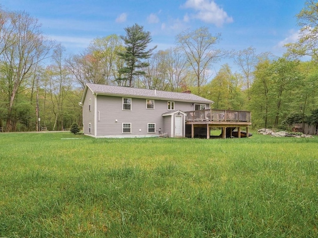 back of house featuring a storage unit, a deck, an outbuilding, and a yard