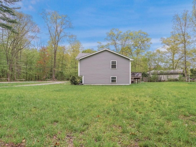 view of side of property featuring a yard and a wooden deck