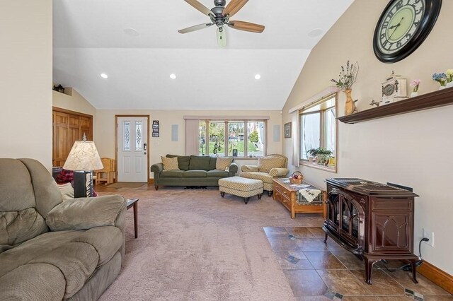 carpeted living area featuring ceiling fan, a wood stove, vaulted ceiling, and recessed lighting