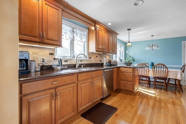 kitchen with tasteful backsplash, brown cabinets, dishwasher, a sink, and light wood-style floors