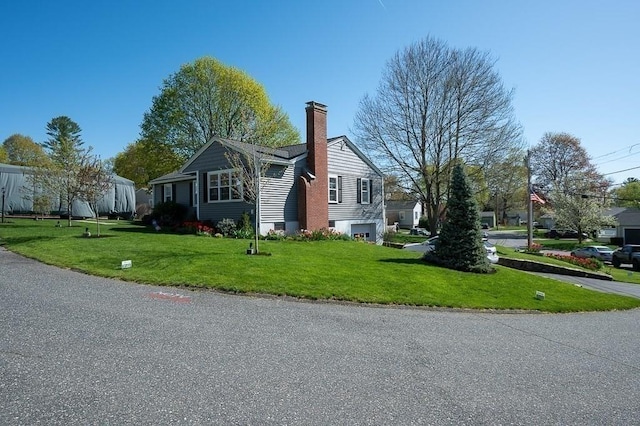 view of side of home with a lawn and a chimney