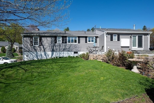 back of property with a lawn and a chimney