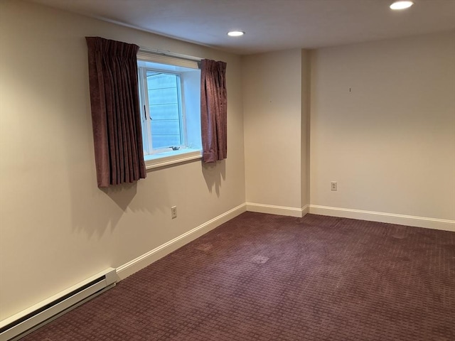 unfurnished room with dark colored carpet and a baseboard heating unit