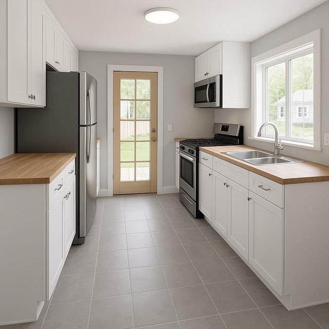 86 Seabrook Rd, Barnstable, MA 02601 - kitchen with stainless steel appliances, a sink, wooden counters, baseboards, and white cabinetry