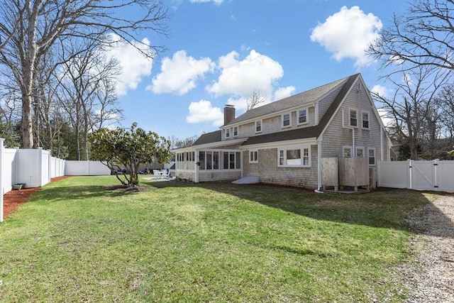 50 Deerfield Rd, Barnstable, MA 02655 - back of property featuring a chimney, a sunroom, a fenced backyard, a gate, and a lawn