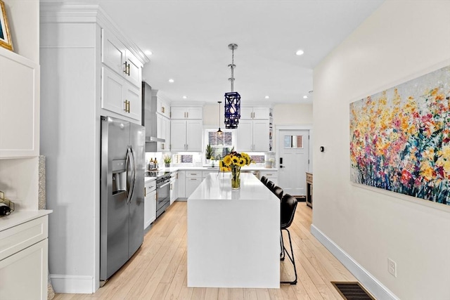 kitchen featuring light countertops, a kitchen island, stainless steel appliances, and recessed lighting