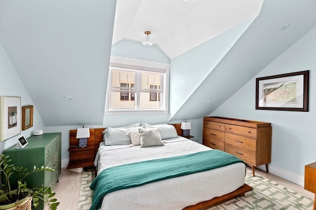 bedroom with baseboards and lofted ceiling
