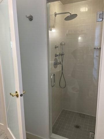 bathroom with a shower stall and baseboards