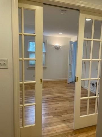 doorway to outside with wood finished floors, french doors, and baseboards