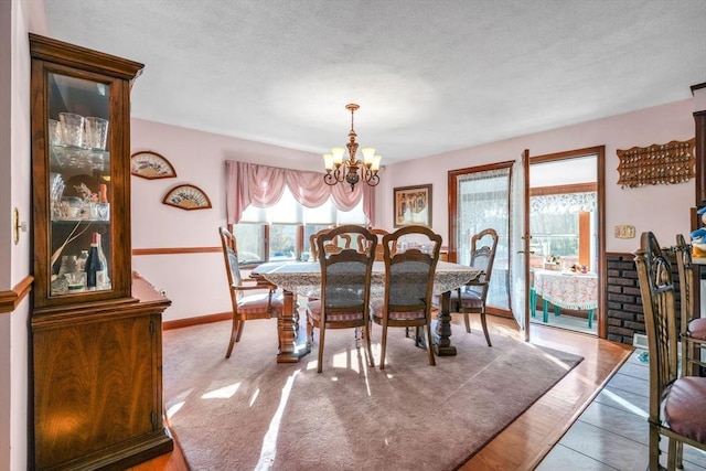 dining space with tile patterned floors, a textured ceiling, and a chandelier