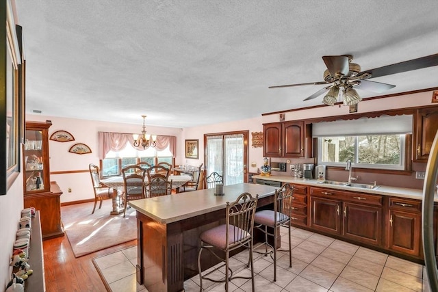 kitchen with sink, radiator heating unit, hanging light fixtures, a breakfast bar, and a kitchen island