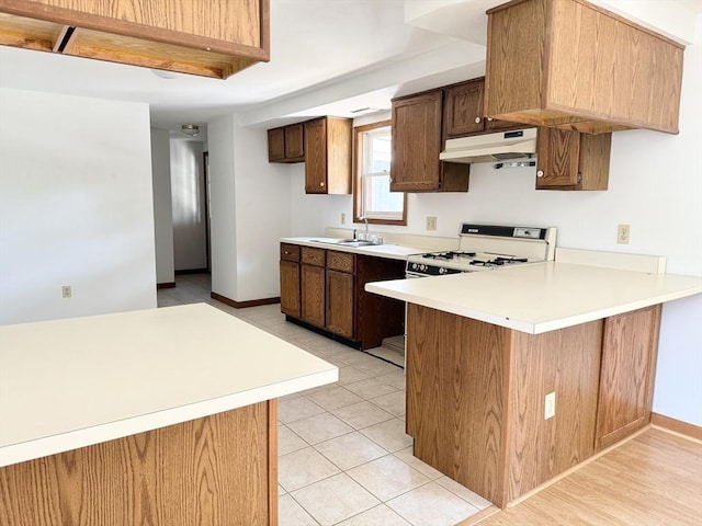 3 Teal Cir, Fairhaven, MA 02719 - kitchen with under cabinet range hood, a peninsula, light countertops, and white range with gas stovetop