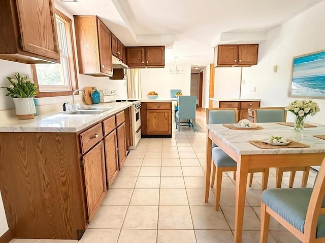 3 Teal Cir, Fairhaven, MA 02719 - kitchen featuring white gas range oven, brown cabinetry, light tile patterned floors, under cabinet range hood, and light countertops