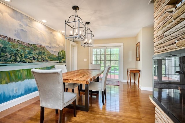 dining space featuring baseboards, recessed lighting, wood finished floors, and a notable chandelier