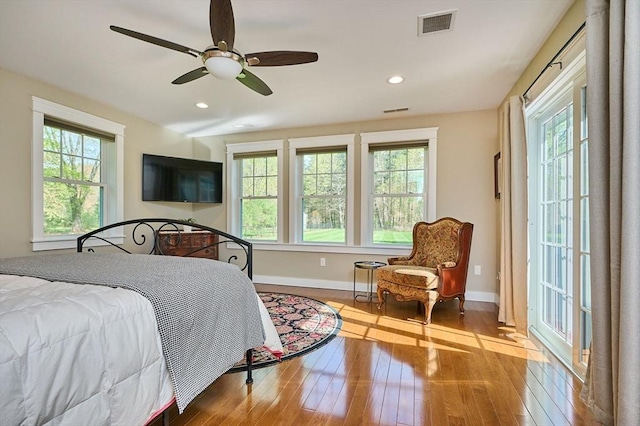 bedroom featuring multiple windows and hardwood / wood-style flooring