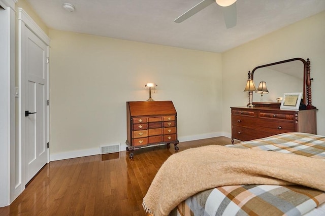 bedroom featuring baseboards, a ceiling fan, wood finished floors, and visible vents