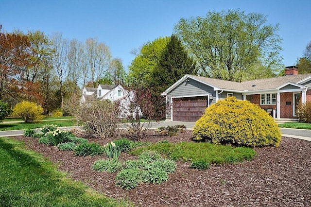 view of property exterior with an attached garage, a chimney, and driveway