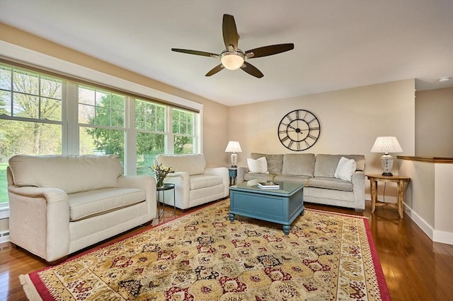 living room featuring baseboards, ceiling fan, and wood finished floors