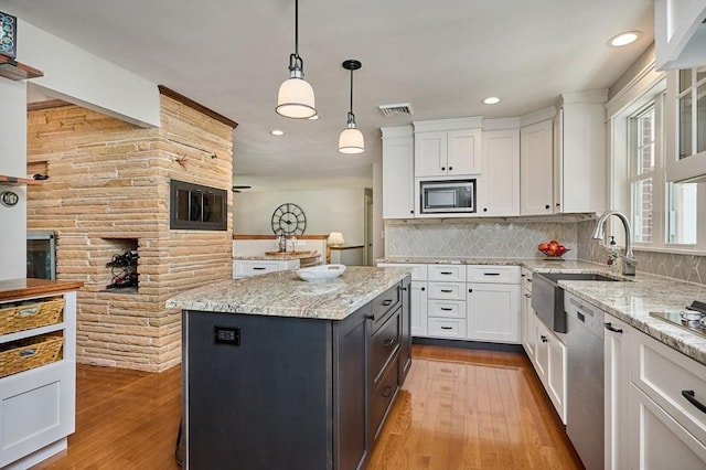 kitchen featuring white cabinetry, appliances with stainless steel finishes, visible vents, and a sink