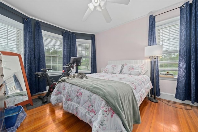 bedroom featuring wood finished floors, baseboards, and a ceiling fan