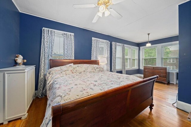 bedroom featuring wood finished floors, baseboards, and a ceiling fan