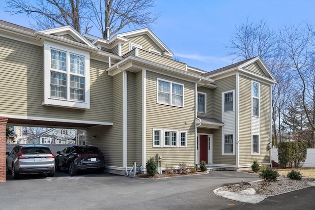 multi unit property featuring aphalt driveway and a carport