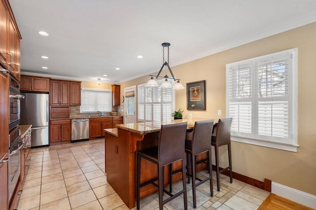 kitchen featuring backsplash, appliances with stainless steel finishes, a breakfast bar area, a peninsula, and crown molding