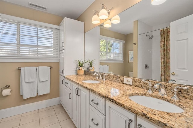 bathroom featuring tile patterned floors, visible vents, toilet, and a sink