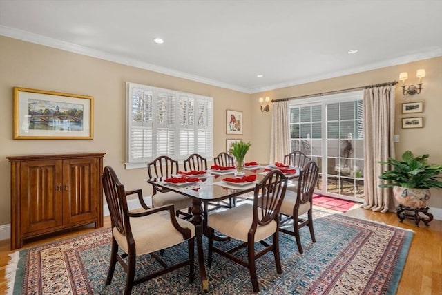 dining space featuring a wealth of natural light, light wood-type flooring, and ornamental molding