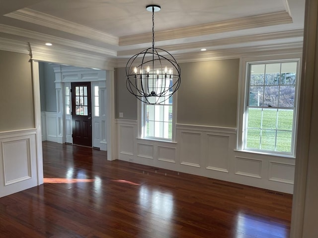 unfurnished dining area with a wealth of natural light, ornamental molding, and an inviting chandelier