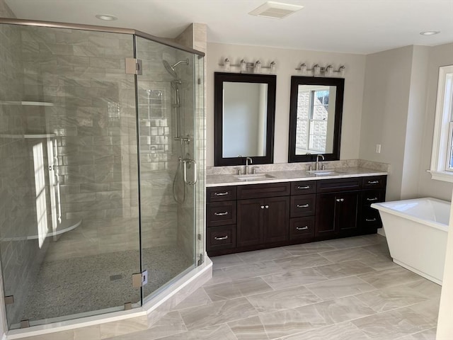 bathroom featuring shower with separate bathtub and vanity