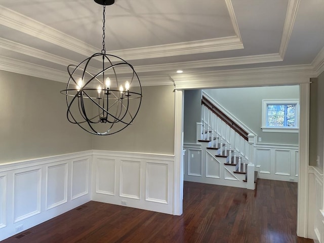 unfurnished dining area with dark hardwood / wood-style flooring, a raised ceiling, crown molding, and an inviting chandelier