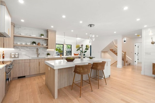 216 Aspinwall Ave, Brookline, MA 02446 - kitchen with a sink, light brown cabinetry, modern cabinets, light wood-style flooring, and recessed lighting